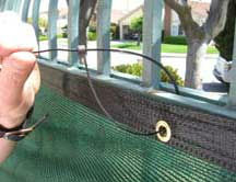 Using a zip tie to attach windscreen to fence